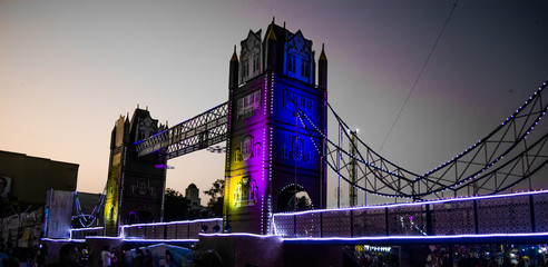 Artificial river bridge covered in lights in diwali fair
