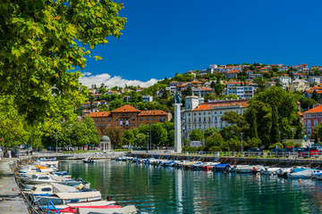 Fototapeta na wymiar Croatia, city of Rijeka, skyline view from Delta and Rjecina river over the boats in front, colorful old buildings, monuments and Trsat on the hill in background 