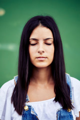 Fototapeta premium Brunette girl facing the camera with her eyes closed dreaming
