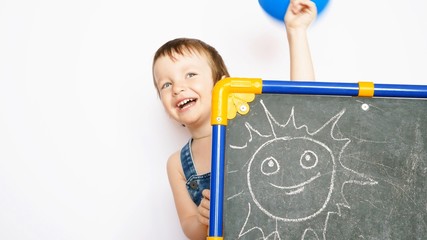 A very beautiful little boy with a blue balloon peeks out from the drawing board and waves a hand...