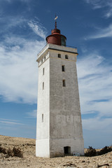 Fototapeta na wymiar LIghthouse with blue sky and clouds råbjerg knude in skagen denmark