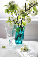 spring pear flowers on a table in the rays of sunlight. table setting, a vase of flowers on the table.