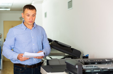 Businessman working with printer in the office