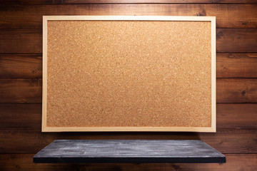 cork board and shelf on wooden background