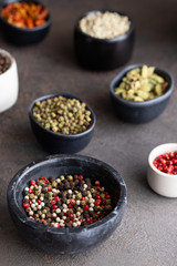 Assortment of  different spices  pepper black ,white, pink ,green and allspice peppercorns in marble bowl. Hot and Spicy Seasoning for cooking concept.