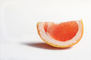 Slice of grapefruit on a white background.