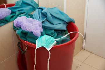 Used mask, cap and clothes in garbage bin