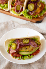 Homemade Bacon Cheeseburger Taco on a white plate, side view. Close-up.