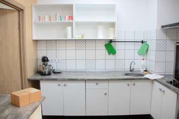 New empty kitchen. All white. Empty shelves. 