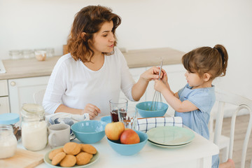 A young mother spends time with her little daughter at home.