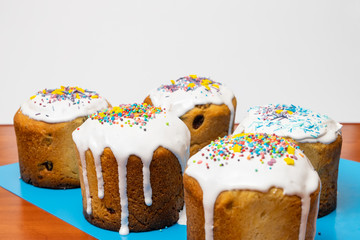 Fresh decorated Easter traditional pastries with white sweet icing and multi-colored sugar powder on it. Christian analogue of Italian panettone