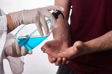 Coronavirus. Doctor give Sanitizer gel to patient's hands . working in home, quarantine. Cleaning hands antibacterial gel to eliminate germs. Stay at home.
