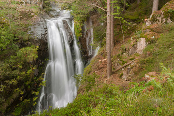 Fototapeta na wymiar waterfall among the misty forest in Italy