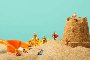 miniature people in swimsuit on the beach