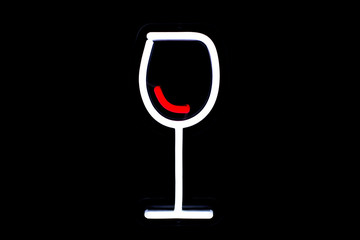 White glass with red wine neon sign on isolated black background. Neon concept. Modern style. Neon sign. Flat lay, copy space, top view.