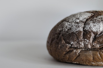 Black bread on a paper background with a seat on the left