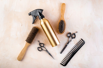 Hairdresser set in beauty salon. Combs, scissors, spray on beige desk top-down