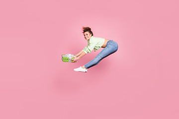 Full length body size view of her she nice attractive athletic cheerful cheery glad girl jumping holding in hands dotted giftbox occasion having fun isolated over pink pastel color background