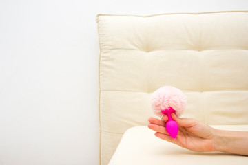 Female in bad holding a vibrator. Sex toy for adult