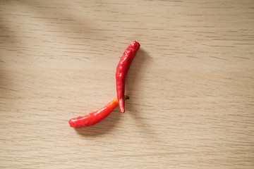 Naklejka premium red hot chili peppers on the wooden table with a top shot.