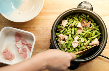 Unrecognized woman hand cooking Thai food with green yardlong bean and meat pork on the top angle shot