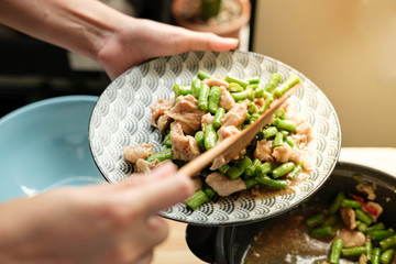 Unrecognized woman hand cooking Thai food with green yardlong bean and meat pork on the top angle shot