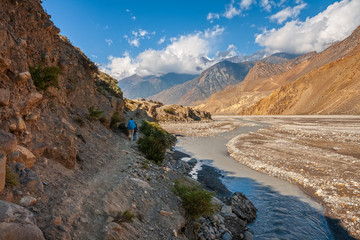 Obraz premium Tourists walk along the riverbank