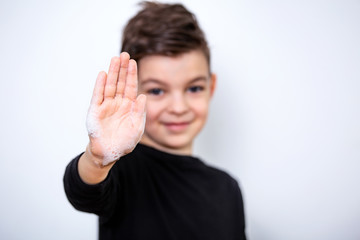 Front view on boys hand with soap foam and text wash your hands, focus on hand, personal hygiene concept. Coronavirus , Covid-19 prevention