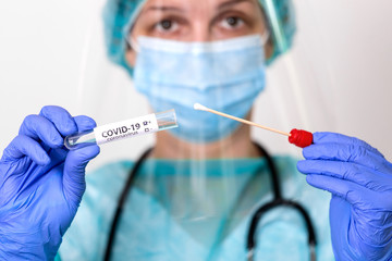 Medical healthcare holding COVID-19 , Coronavirus swab collection kit, wearing PPE protective suit...