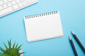 Blue desk office with laptop, smartphone and other work supplies with cup of coffee. Top view with copy space for input the text. Designer workspace on desk table essential elements on flat lay