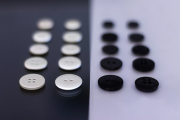 A group of clothing buttons lined up in rows and placed on top of each other to create a contrast
