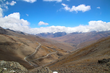 Plakat Plateau winding road, blue sky and white clouds, snowy mountains in the distance
