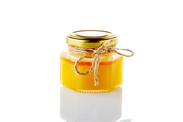 jar of honey and honeycomb isolated on white