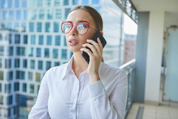 Real estate agent talking on the phone. in the background modern buildings, office buildings