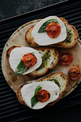 Italian traditional bruschetta with tomato, mozzarella cheese and pesto sauce. Grilled caprese sandwich