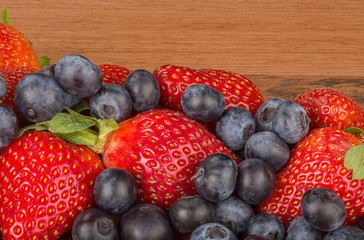 strawberries and blueberries on wooden background