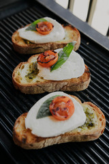Italian traditional bruschetta with tomato, mozzarella cheese and pesto sauce. Grilled caprese sandwich