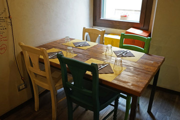 Interior design and table arrangement of local Italian pasta restaurant decorated with colorful wooden furniture