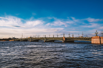 Obraz premium Granite embankment in Saint Petersburg, beautiful orange sun, bright sunset, the Neva river and the Peter and Paul fortress