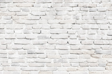 Limewashed old brick wall in white texture close-up