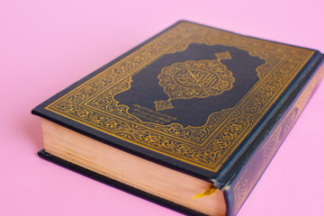 Fototapeta premium Quran on a light pink background. Space fot text. Ramadan kareem.