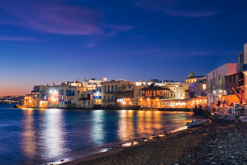 Harbor and colorful waterfront houses of Little Venice romantic spot illuminated in night. Mykonos...