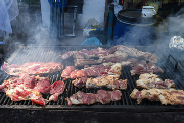 Chef preparing meat on the grill, during outdoor outside food festival, food truck
