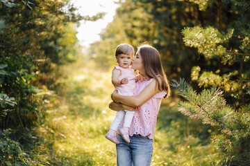 Fototapeta premium Young mother with her adorable little baby in forest