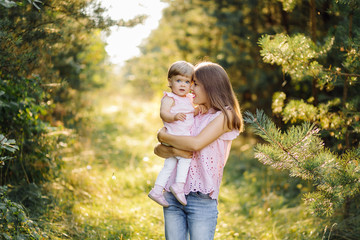 Fototapeta premium Young mother with her adorable little baby in forest