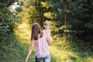 Fototapeta premium Young mother with her adorable little baby in forest