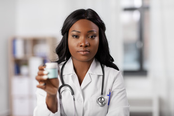 medicine, people and healthcare concept - african american female doctor or nurse with drugs at hospital