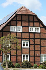 Fachwerkhaus mit Photovoltaikanlage bei blauem Himmel fotografiert