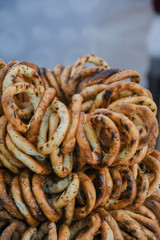 German pretzels stack one over each other, group of thin dry pretzels on rope on display