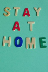 stay at home phrase written in wooden letters on a colored cardboard, coronavirus advertisement